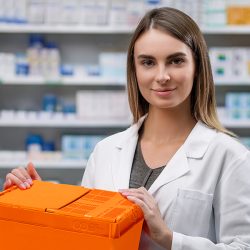 Pharmacist with an orange reusable box of SCL