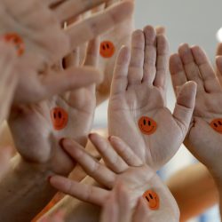Orangene Smileys auf Händen